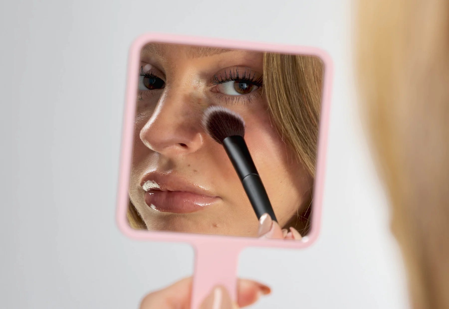Brushworks makeup brush reflected in a pink hand mirror