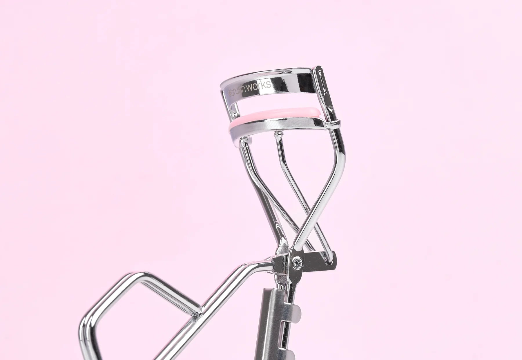 Pink Brushworks eyelash curler on a soft pink background