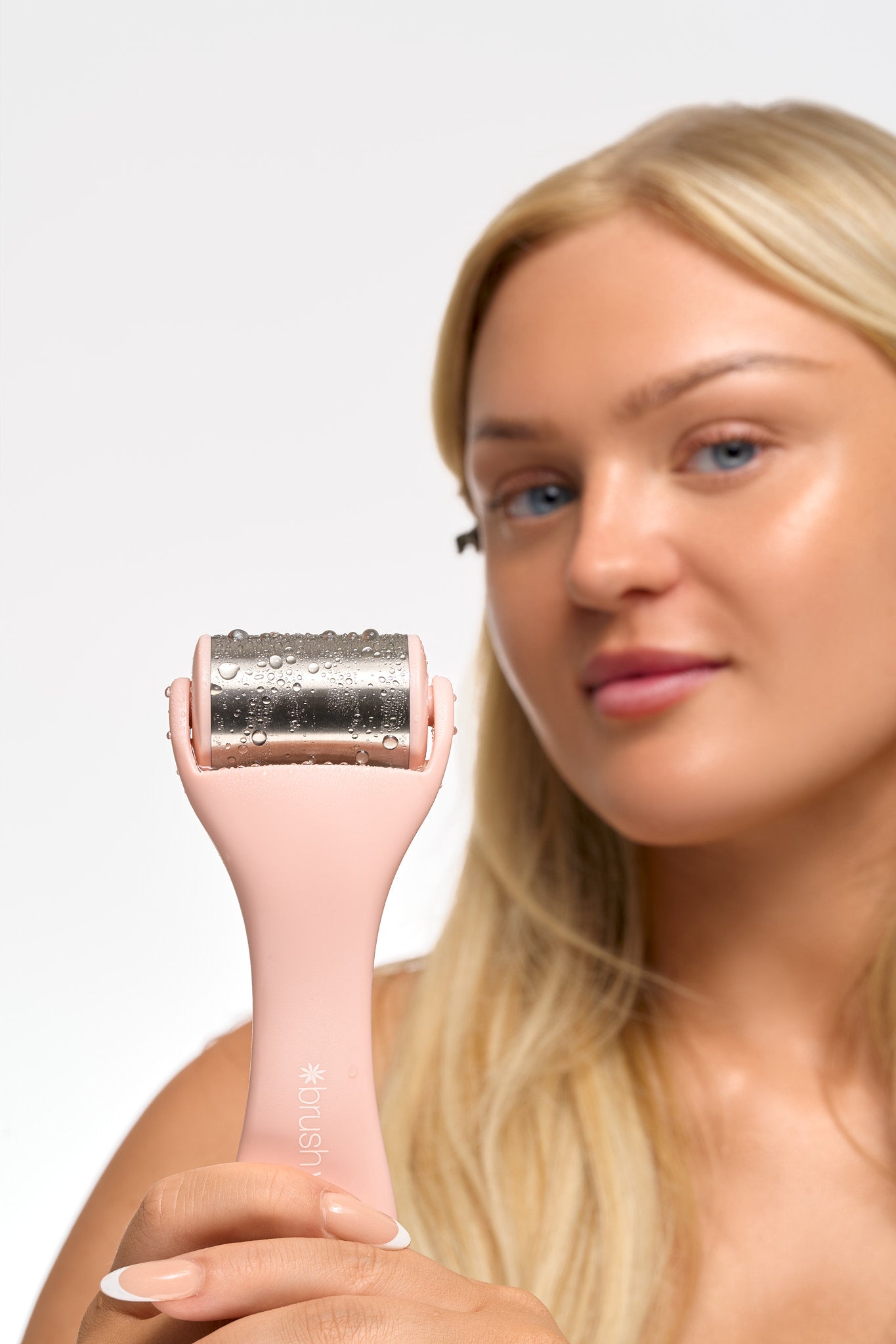 Model applying a soft skincare puff to glowing skin