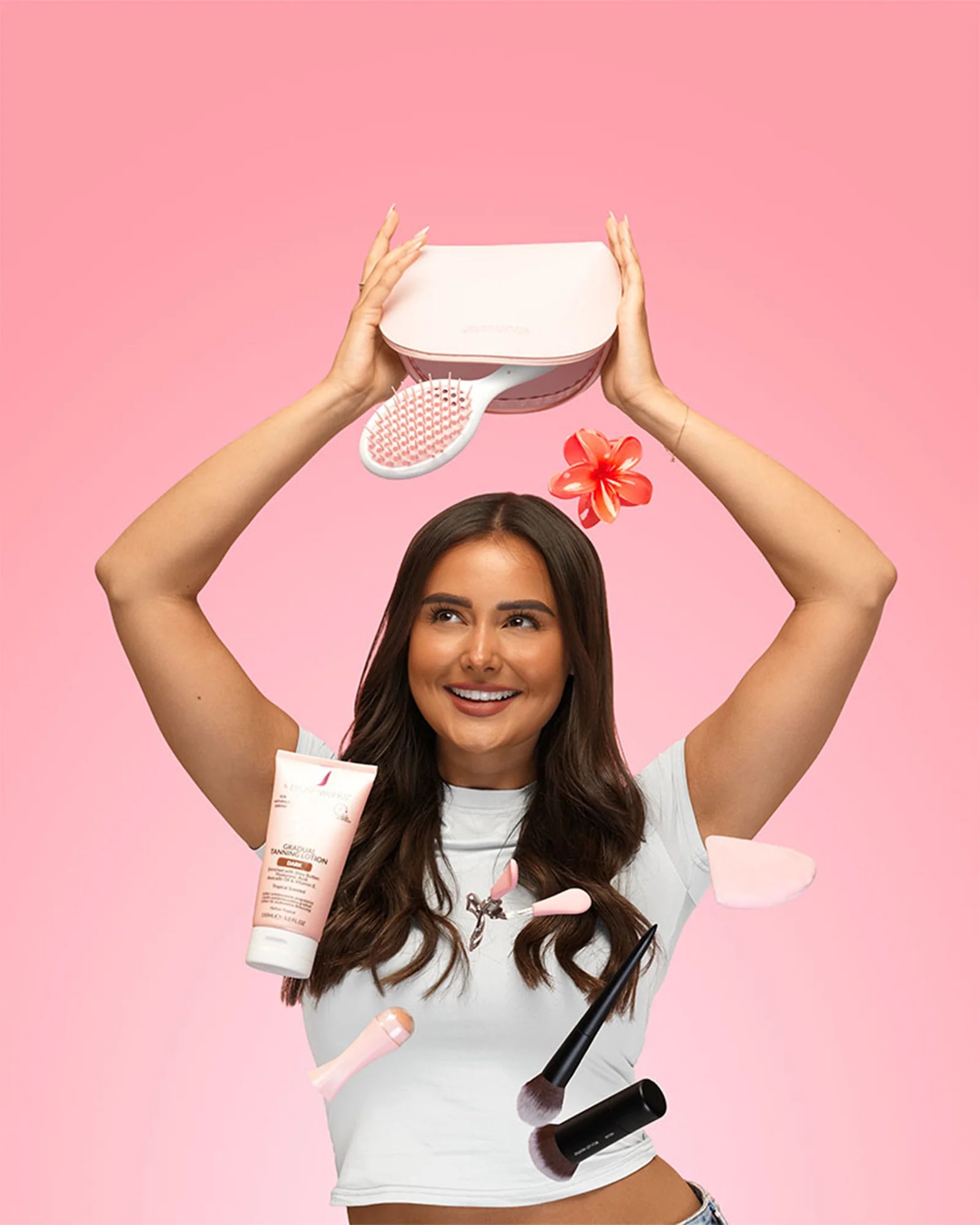 Model holding Brushworks beauty essentials against a pink background